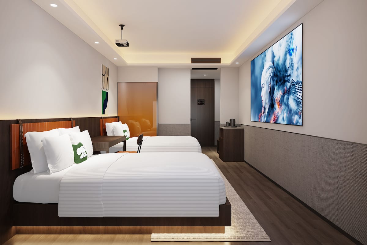Une chambre d’hôtel moderne avec un grand lit, une table de chevet, une télévision et une grande fenêtre.