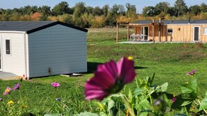 Un petit bâtiment d’un seul étage, à l’extérieur gris et à la structure en bois, surmonté d’un toit.