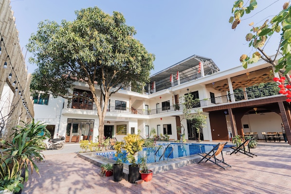 A courtyard with a swimming pool, potted plants, and outdoor seating. - Thach's Homestay Tam Coc (Hoa Lu)