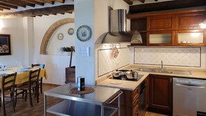 A kitchen with wooden cabinets, a stainless steel range hood, and a dishwasher. - Villa sleeps 14 with private pool (Monteroni d'Arbia)