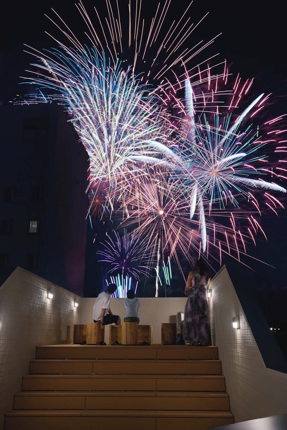 A staircase leading up to a balcony with a view of fireworks display.