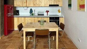 A modern kitchen with wooden cabinets, a red refrigerator, and a dining table with four chairs. - Cozy, centricand styled 2-bedroom apartment in enchanting Cuenca (Cuenca)