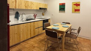 A compact kitchen with wooden cabinets, a dining table with chairs, and a tiled floor. - Cozy, centricand styled 2-bedroom apartment in enchanting Cuenca (Cuenca)
