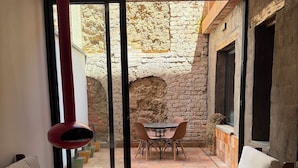 A modern living room with a large sliding glass door leading to an outdoor patio. Inside, there are two sofas and a dining table with chairs. - Cozy, centricand styled 2-bedroom apartment in enchanting Cuenca (Cuenca)
