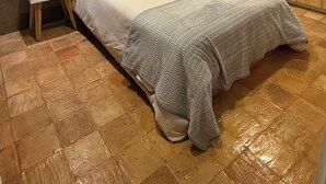A bedroom with a bed, wooden wardrobe, and a small bedside table with a red pot. - Cozy, centricand styled 2-bedroom apartment in enchanting Cuenca (Cuenca)