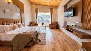A spacious bedroom with a large bed, a TV, and a wooden ceiling. -  Wonderwood Corbett Resort (1min walk to River with Deep Jungle Trail) (Ramnagar)