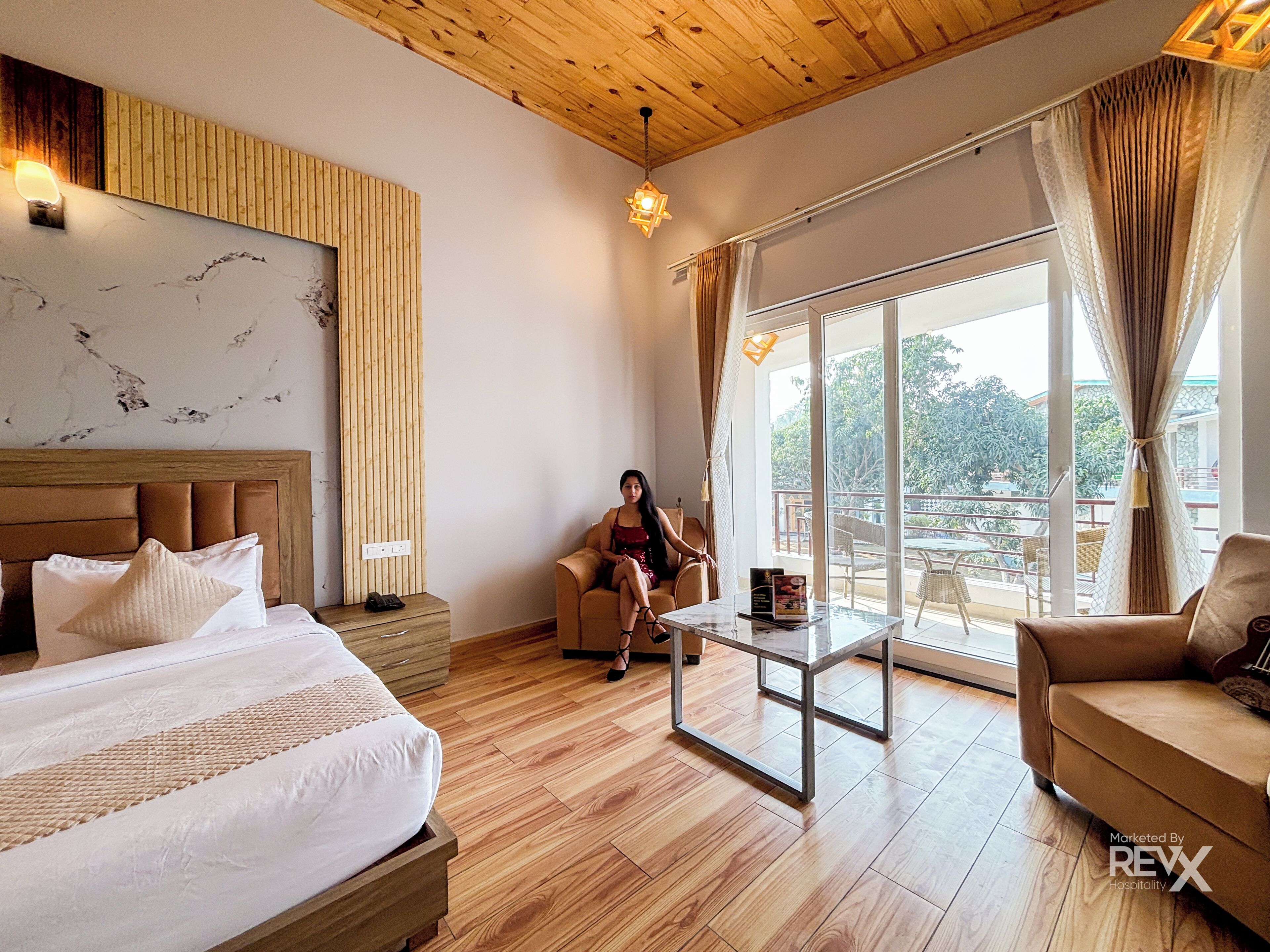 Une chambre d’hôtel avec un grand lit, un canapé, une table basse et un balcon avec vue.