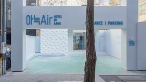 The entrance to the Air by Aank Hotel, featuring a modern design with a textured facade and a clear pathway leading to the entrance. - Anook Air Hotel Gaebong (Seoul)