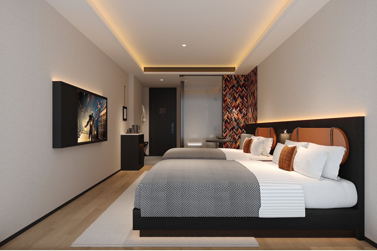 Quarto de hotel moderno com uma cama grande, uma escrivaninha e um espaço de estar.