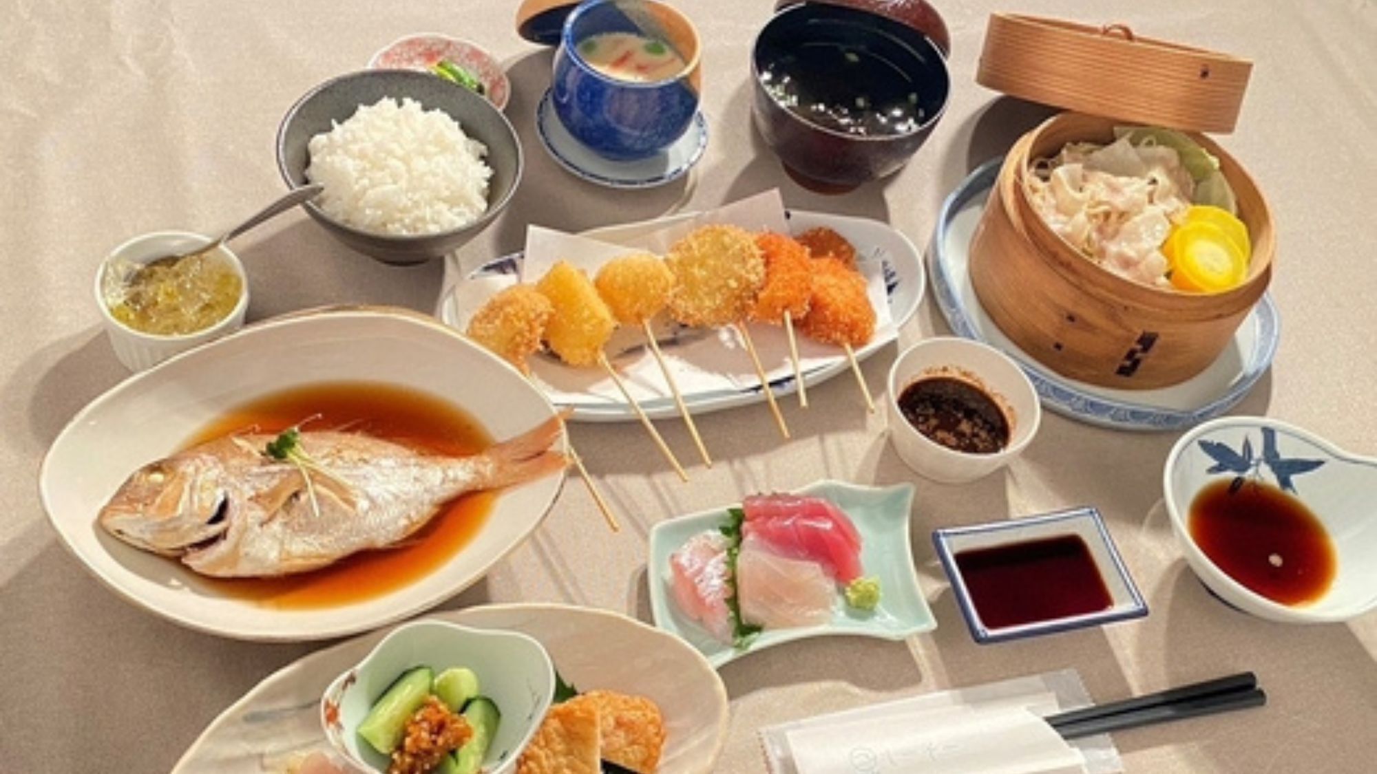A variety of Japanese dishes including sushi, tempura, and a bowl of rice.