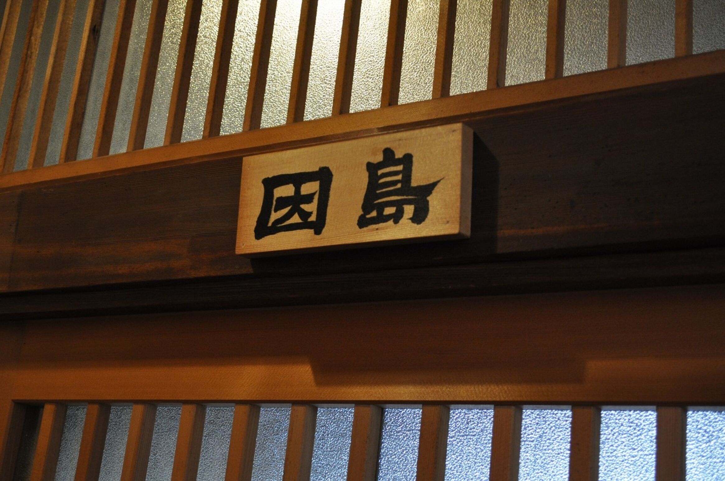 A wooden sign with Japanese characters.