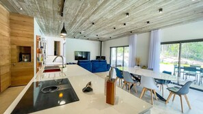 Relax in this open-plan living space with a central island kitchen, seating area, and dining table.