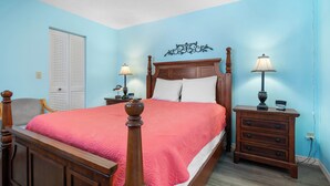 A bedroom with a wooden bed, two bedside tables with lamps, a chair, and a wardrobe.