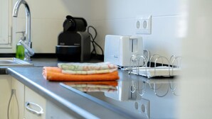 Eine Küche mit modernem Design, ausgestattet mit einer Edelstahl Arbeitsplatte, einem eingebauten Toaster und einem Wasserkocher.