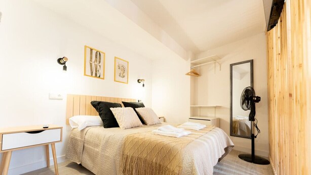 Ein Schlafzimmer mit Bett, Nachttisch und Spiegel.