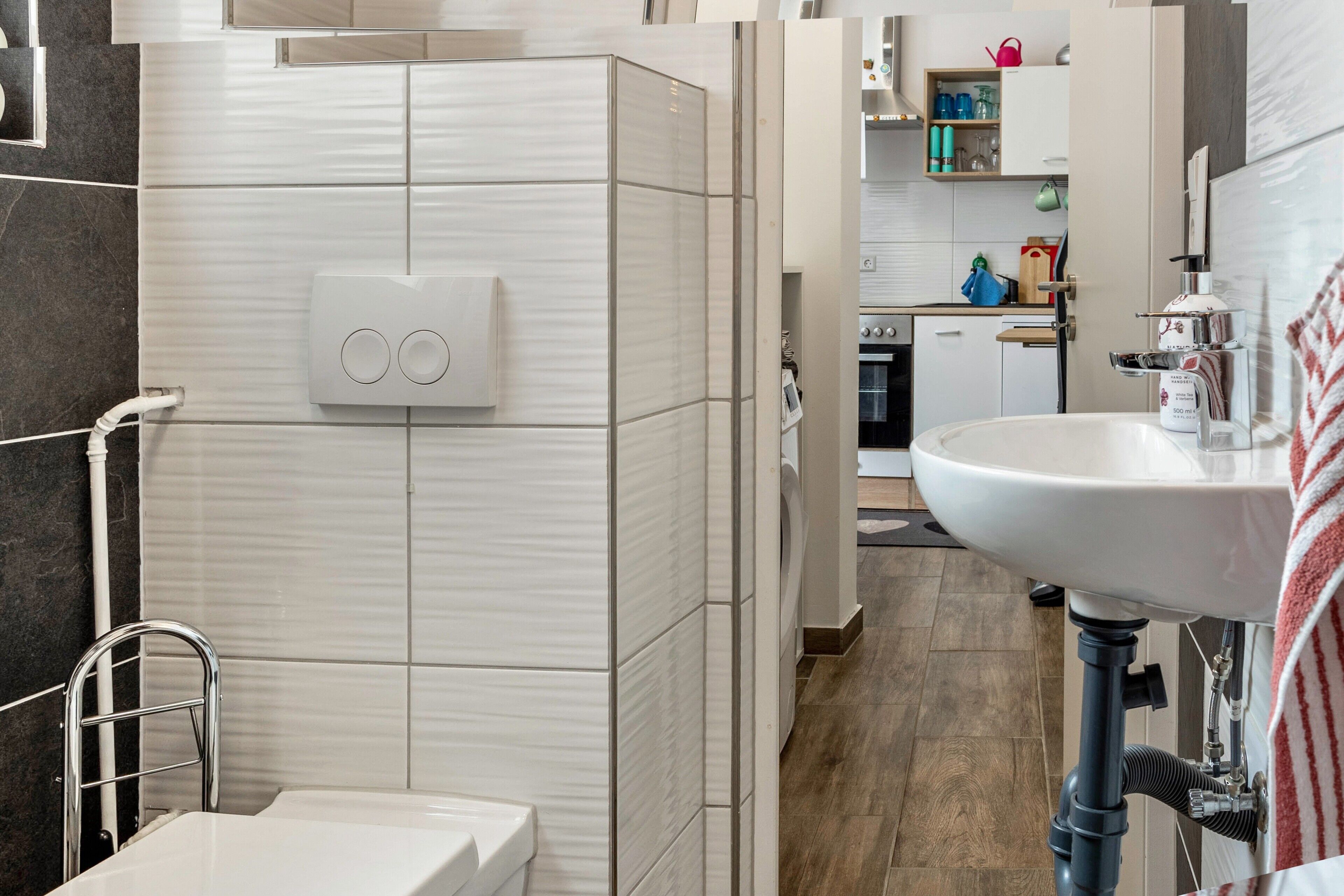 A modern bathroom with a toilet, sink, and shower area.