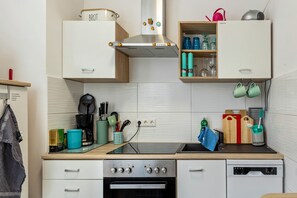 Une cuisine équipée d’une cuisinière, d’un four, d’un lave-vaisselle et de placards.