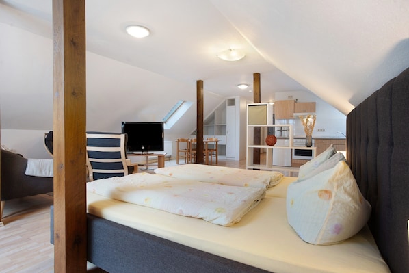 Une chambre à coucher avec un lit, une télévision, un bureau et une chaise.