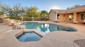 A swimming pool with a hot tub, surrounded by a patio area with a house in the background. - Home on Golf Course w/ Private Pool in Phoenix! (Phoenix)