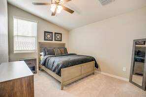 Cozy retreat with a comfortable bed, bedside table, and mirror.