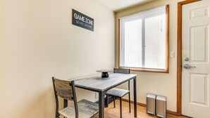 Ein Essbereich mit Tisch, Stühlen und einem Schild mit der Aufschrift 'GAME ZONE DO NOT DISTURB'.