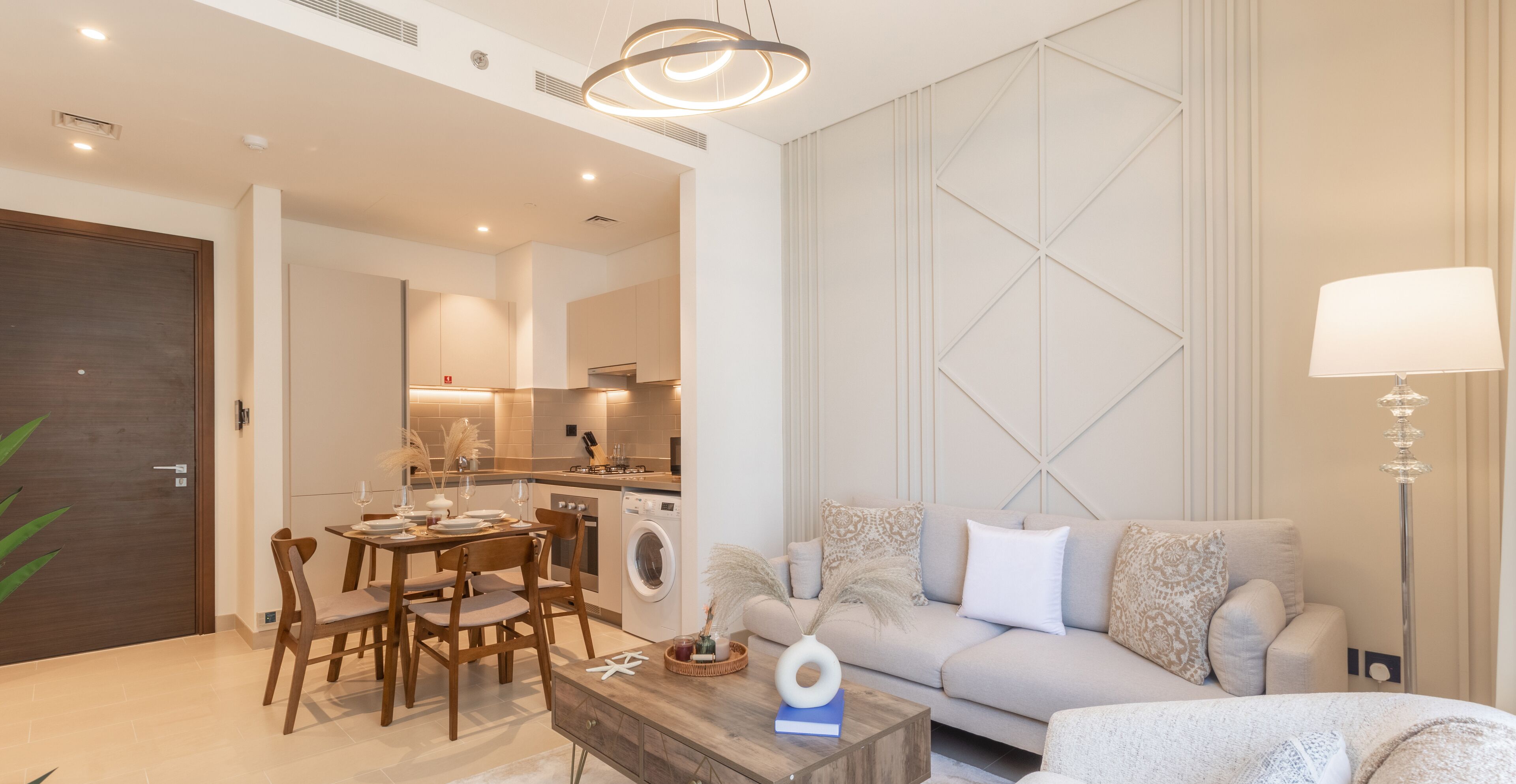 A modern living room with a sofa, a coffee table, and a dining area with chairs and a table.