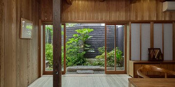 Un interior japonés tradicional con puertas correderas que dan a un jardín.