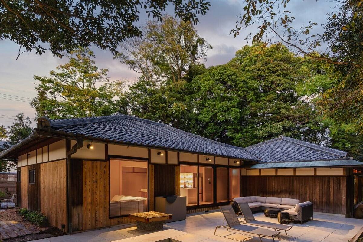 Une maison moderne dotée d’un grand patio, d’une piscine et d’une façade en bois.