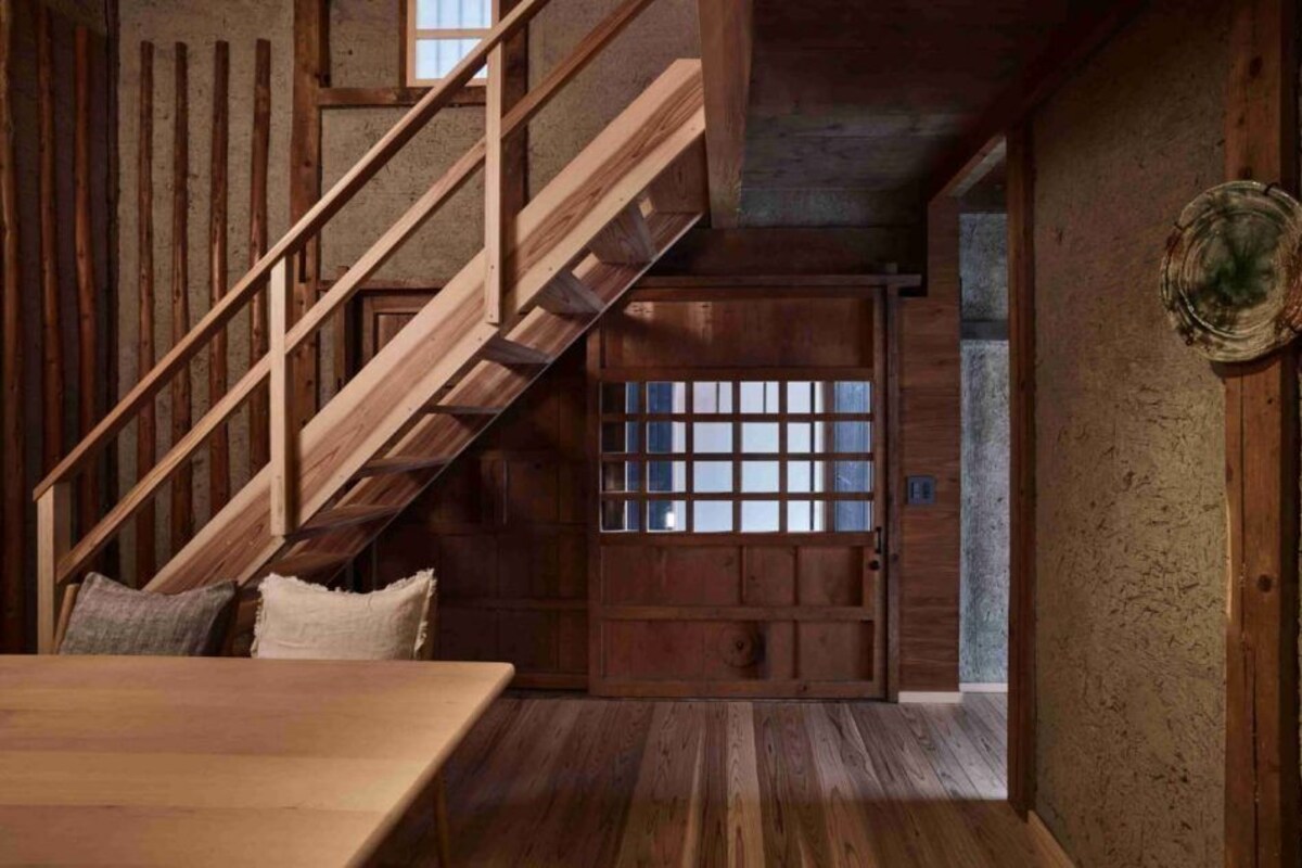 A wooden staircase leading to a room with a traditional Japanese sliding door.