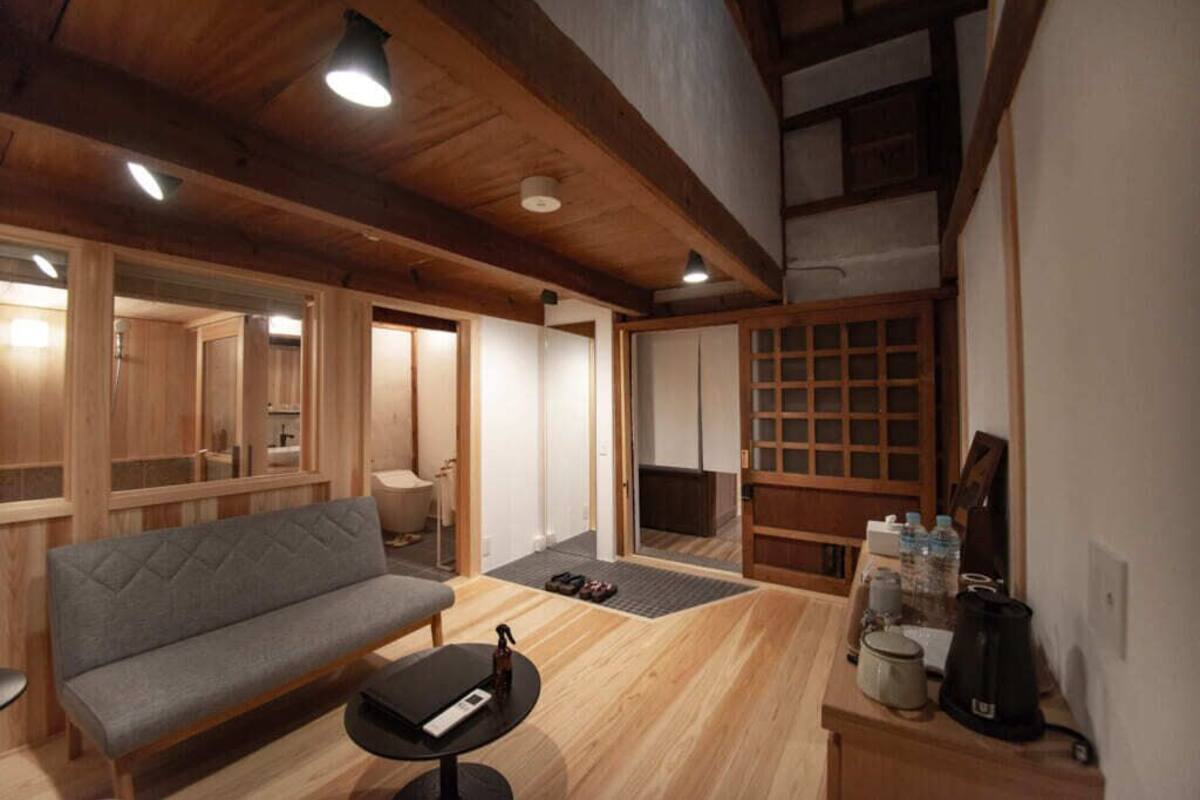 Une pièce chaleureuse avec un canapé, une petite table, une cheminée et des murs en bois.