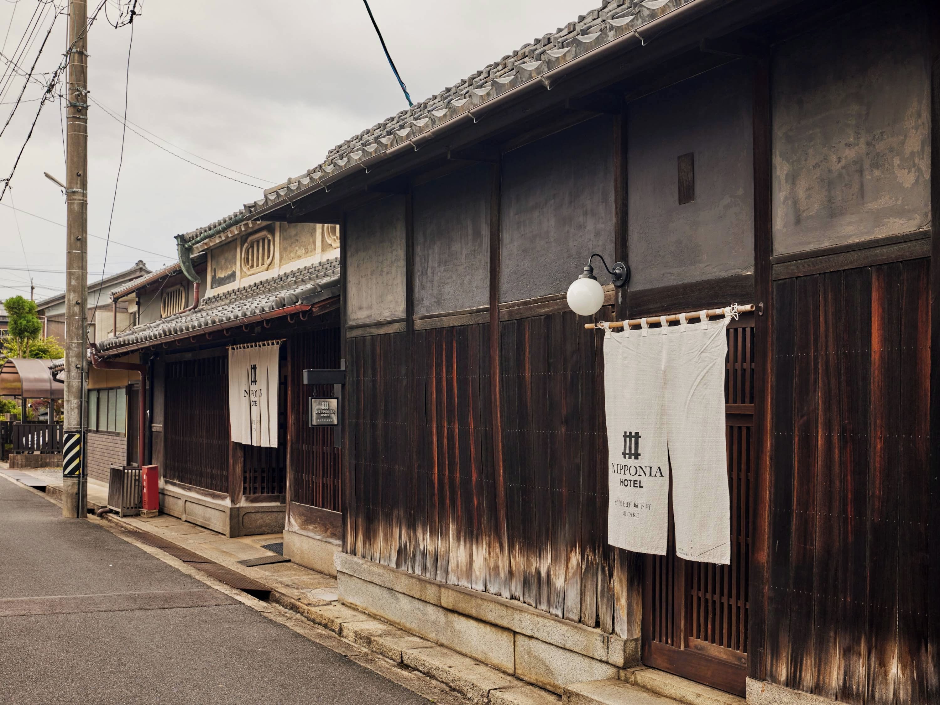 A traditional Japanese building with a wooden exterior, a tiled roof, and a sign indicating it is the Yipponia Hotel.