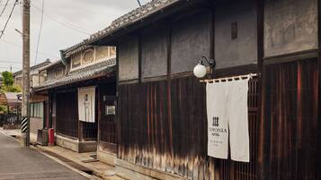 A traditional Japanese building with a wooden exterior, a tiled roof, and a sign indicating it is the Yipponia Hotel.