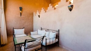 A room with a bed, a table, and chairs. - Residence Dar Lamia Marrakech: 2 Bedroom Apartment (Dar Caïd Layadi)