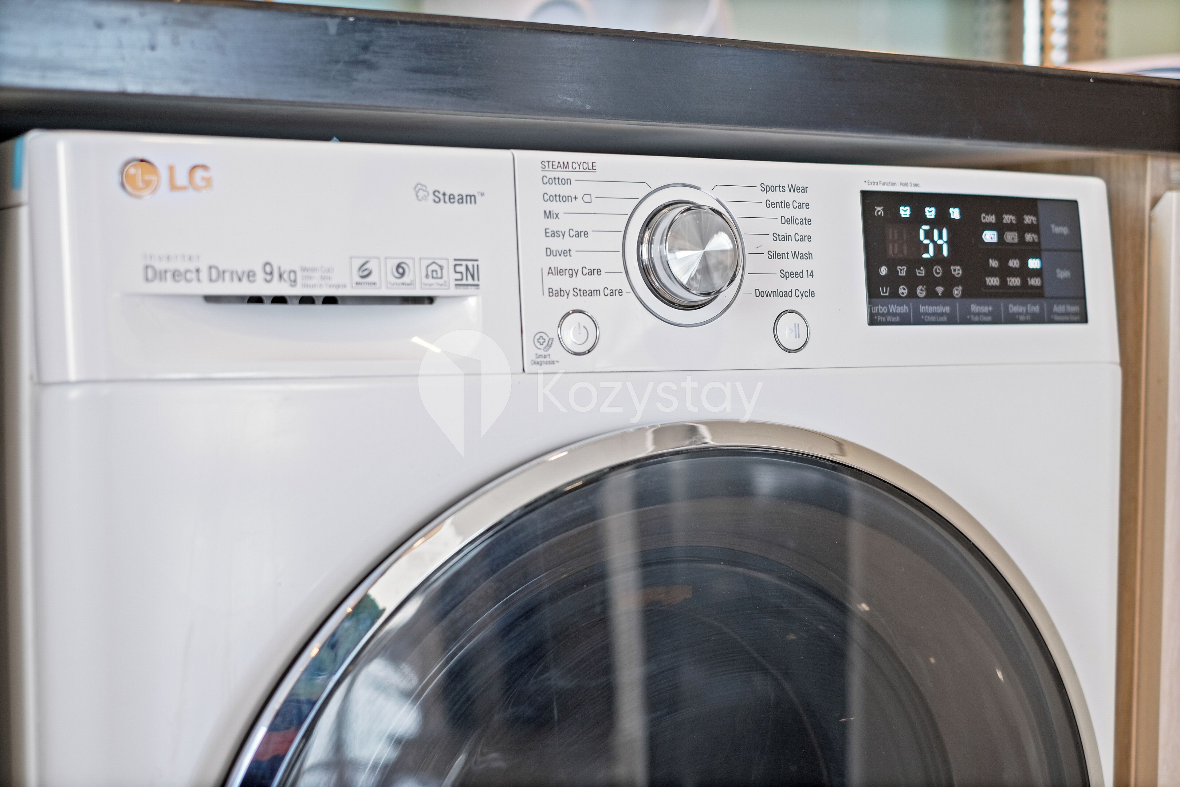 A front view of an LG Direct Drive 9kg washer with a digital display and various cycle options.