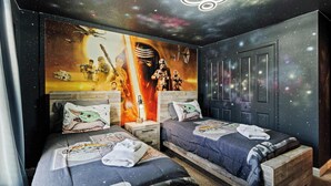 A bedroom with two beds, a galaxy-themed mural, and a starry ceiling. - Chic 4BR Home with Mickey & Star Wars Rooms (Kissimmee)