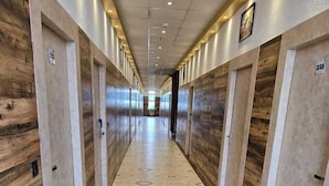A long, narrow hallway with wooden paneling on the walls and a patterned floor. - Avadh Sunshine Palace Hotel & Resort (Tarabganj)