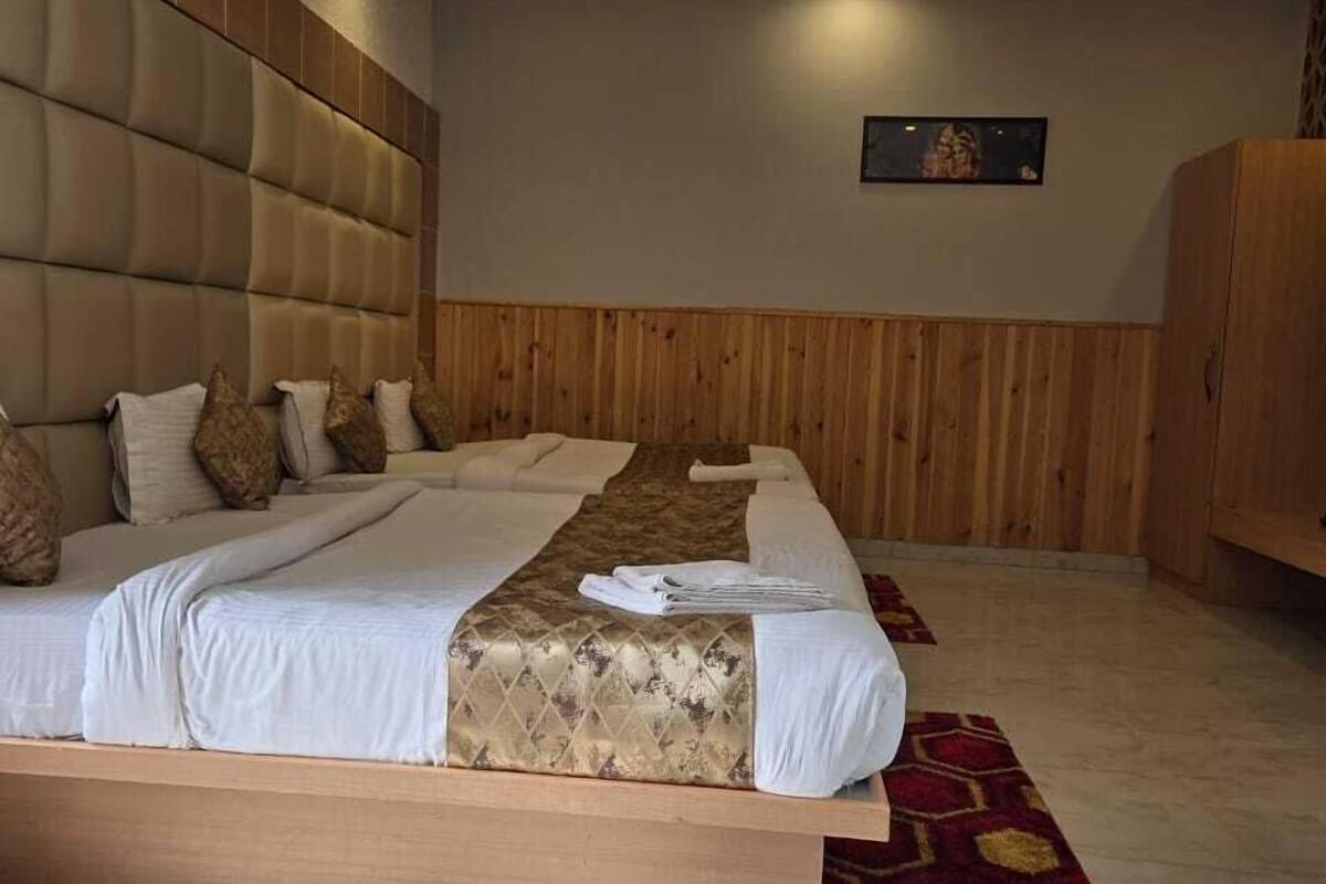 Hotellihuone, jossa on suuri sänky, kattotuuletin ja puinen pääty.