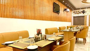 A conference room with a long table set for a meeting, surrounded by leather chairs. - Avadh Sunshine Palace Hotel & Resort (Tarabganj)