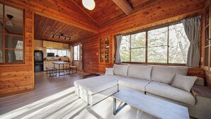 A wooden cabin interior with a dining area, sofa, and large windows. - rinne 2nd living Kitakaruizawa Forest (Tsumagoi)
