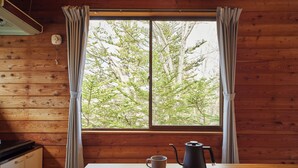 A wooden cabin interior with a window, curtains, a table, a kettle, and a mug. - rinne 2nd living Kitakaruizawa Forest (Tsumagoi)