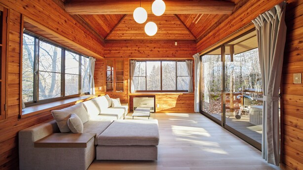 A log cabin interior with a sofa, large windows, and a fireplace. - rinne 2nd living Kitakaruizawa Forest (Tsumagoi)