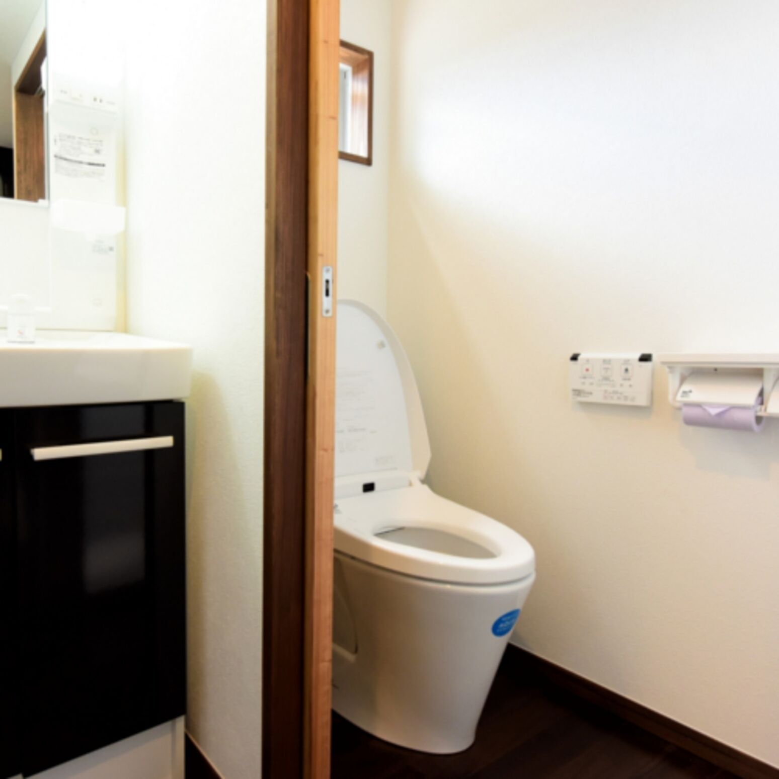 A bathroom with a white toilet, a sink, and a mirror.