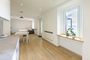 Eine moderne Küche mit Essbereich, einer eingebauten Bank und einem Fenster mit Pflanzen.