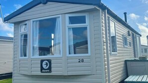 A mobile home with a bay window, a 'SWIFT' sign, and the number '28' on the side. - SeaSalt -Low cost accommodation, Harlyn Sands (Padstow)