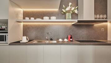 A modern kitchen with a built-in sink, a coffee maker, and a vase with flowers on the countertop.