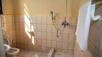 Ein kleines Badezimmer mit Toilette, Dusche und Badewanne.