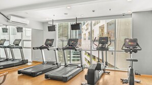 A gym with treadmills, elliptical machines, and a stationary bike.