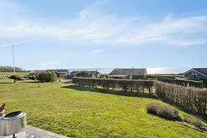A residential area with houses, a grassy field, and a body of water in the background. - Lovely holiday home with sea view (Faaborg)