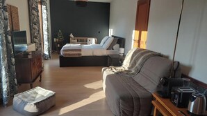 A modern living room with a sofa, a coffee table, a TV, and a small dining area with a toaster and kettle. - El Nido BY LAVILLA25 Noaillan (Noaillan)