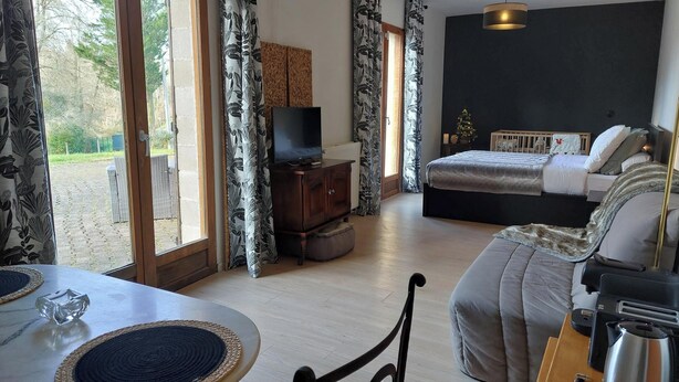 A bedroom with a bed, a TV, and a small Christmas tree. - El Nido BY LAVILLA25 Noaillan (Noaillan)